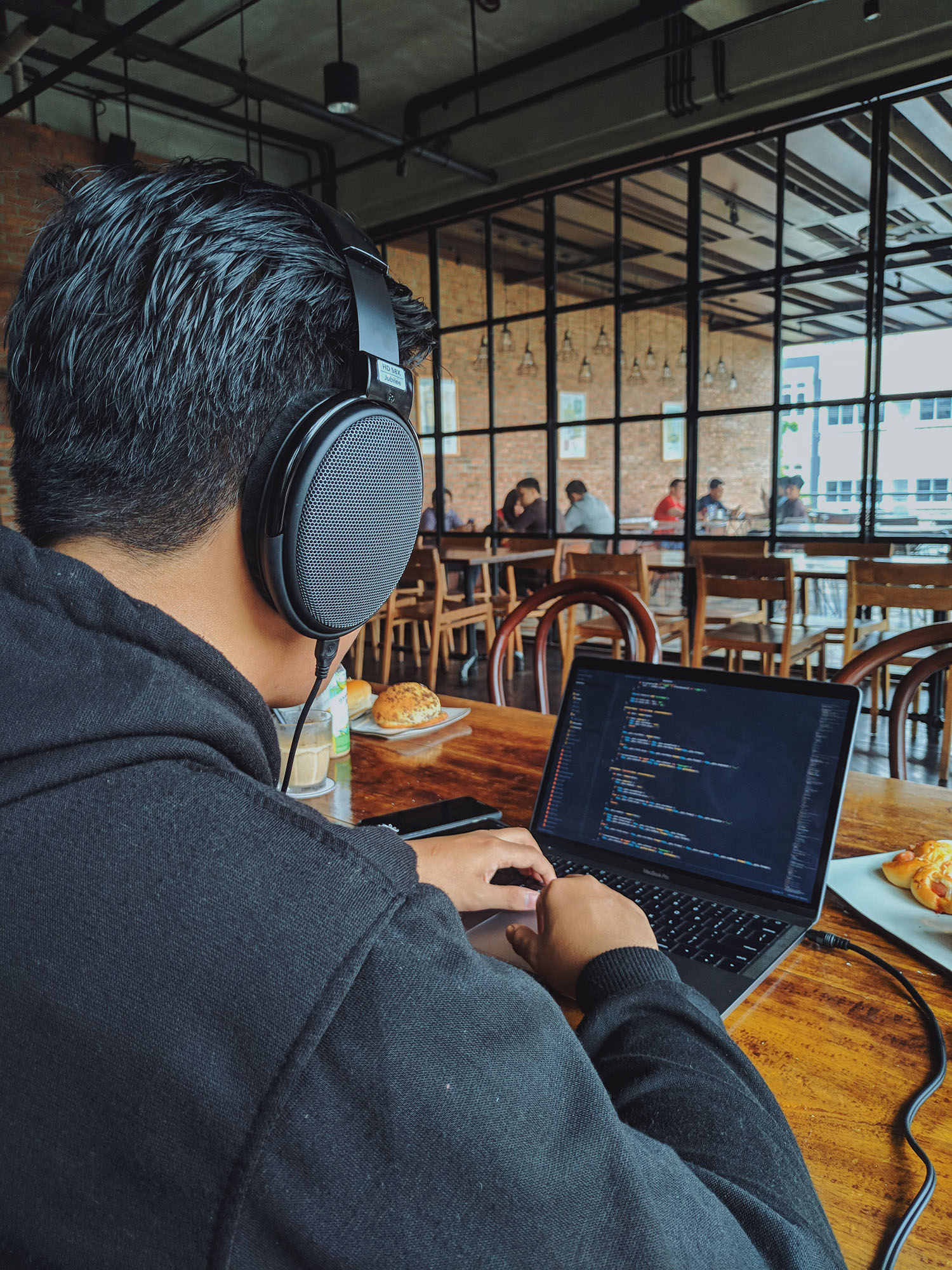Coder wearing headphones in a co-working environment